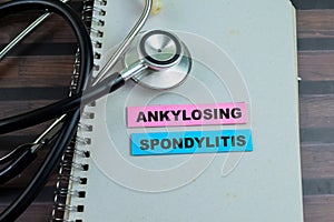 Concept of Ankylosing Spondylitis write on sticky notes with stethoscope isolated on Wooden Table