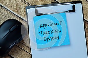 Concept of Applicant Tracking System write on sticky notes isolated on Wooden Table