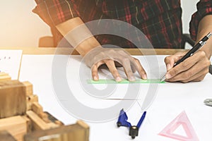 Concept architects,engineer holding pen pointing equipment architects On the desk with a blueprint