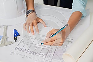Concept architects,engineer holding pen pointing equipment architects On the desk with a blueprint in the office. .Selective Focus
