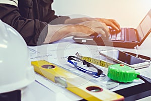 Concept architects, equipment architects On the desk with a blueprint in the office, and working laptop