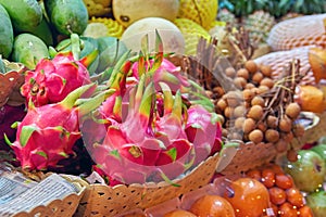 Concept asian food market. Dragon fruit Pitahaya and Dragon eye Longan on counter street night vendor of fruits. Exotic fruits