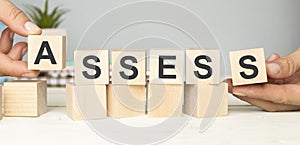 Concept of ASSESS on wooden cubes,