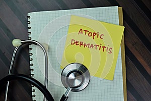 Concept of Atopic Dermatitis write on sticky notes with stethoscope isolated on Wooden Table