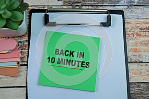 Concept of Back In 10 Minutes write on sticky notes isolated on Wooden Table