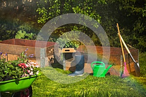 Wheelbarrow with Gardening tools in the garden. watering in the garden. rainbow formation