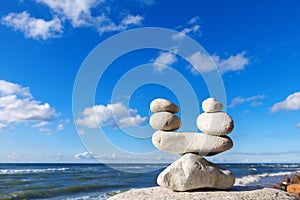Concept of balance between work and life. Balance stones against the sea. Rock zen in the form of scales