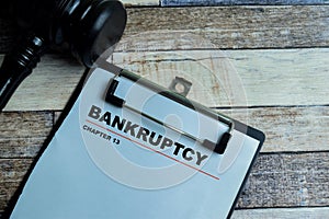 Concept of Bankruptcy Chapter 13 write on paperwork with gavel isolated on wooden background