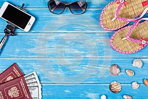 The concept of a beach holiday. Beach accessories lying on a blue wooden background.