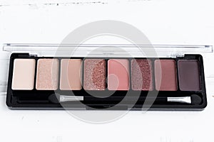 The concept of beauty. An eye shadow palette on a white wooden background, a cosmetic eye shadow product as an