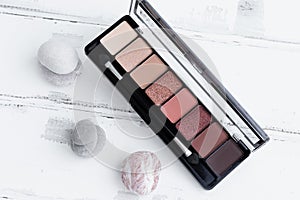 The concept of beauty. An eye shadow palette on a white wooden background, a cosmetic eye shadow product as an
