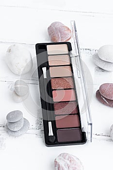 The concept of beauty. An eye shadow palette on a white wooden background, a cosmetic eye shadow product as an