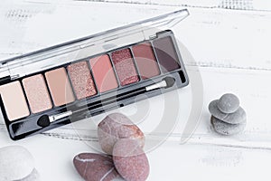 The concept of beauty. An eye shadow palette on a white wooden background, a cosmetic eye shadow product as an