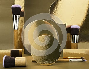 Concept of beauty and make-up. Professional brush for makeup, shiny golden shapes on the brown background.Empty space for design