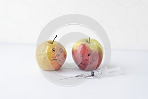 The concept of beauty procedures and rejuvenation. Elastic and shriveled apples and a syringe with a drug for injection