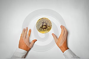 Concept of a bitcoin hype with two hands reaching for a bitcoin coin