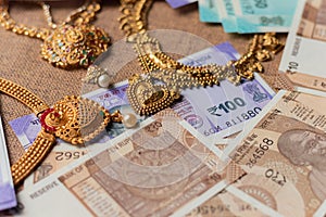 Concept of black money, IT raid, confiscated or unaccounted Money showing Indian currency notes with jewelry
