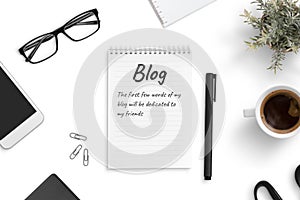 Concept of blogging and freelancing. A few blog words on a pad paper on office desk