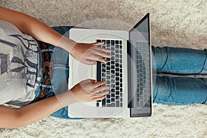 The concept of blogging, working on a laptop. Using a laptop sitting on floor.