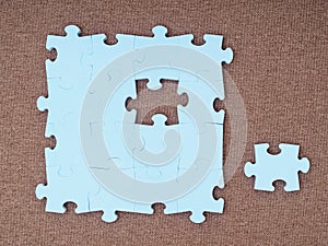 Concept of blue puzzle pieces on brown background