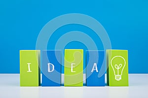 Concept of brainstorming and new ideas. Blue and green blocks in a row with drawn word idea and light bulb