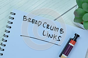 Concept of BreadCrumb Links write on book isolated on Wooden Table