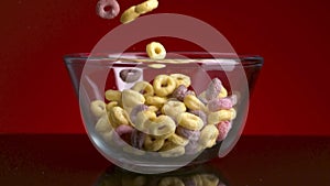Concept of breakfast and food. Stock footage. Close up of colorful delicious and sweet corn rings falling down into