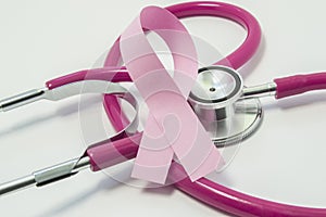 Concept of Breast Cancer. Pink ribbon near the pink-purple stethoscope doctor of breast screening, symbolizing the diagnosis, trea