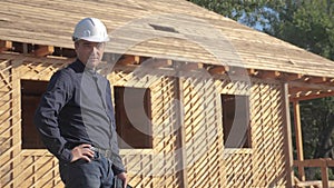 Concept building constructing architect slow motion video. man builder in a helmet stands at construction holding