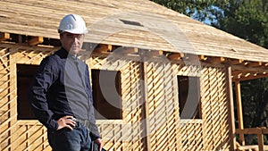 Concept building constructing architect slow motion video. man builder in a helmet stands at construction holding