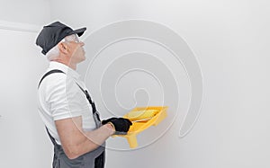 Concept building, painter in gloves and uniform holding painting roller repair apartment home