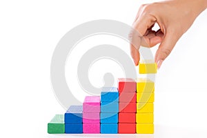 Concept of building success foundation. Women hand put wooden blocks in the shape of a staircase