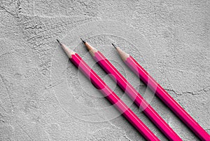 Concept of business, Back to school, three sharpened pencils on a background of gray plaster texture, space for text