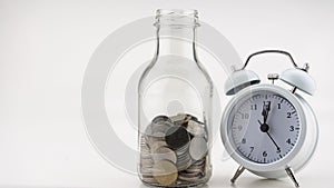 Concept Business finance and Shopping sale Coins in jar with White alarm clock Business objects isolated on white background