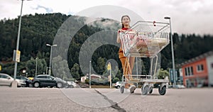 Concept of buy and sell, trade industry. Woman loading products from cart to a car. Buying in supermarket. Gir standing