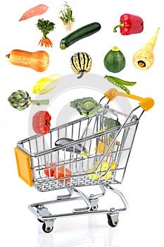 Concept of buying vegetables with a supermarket trolley on a white background