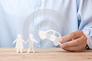 The concept of car rental, credit or insurance. Man in shirt is holding car in his hand and next to his family