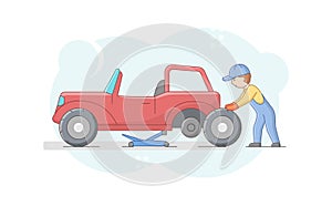 Concept Of Car Repair Shop. Cheerful Mechanic In Uniform Is Changing Tires On Retro Vehicle Using Tools And Car Lift