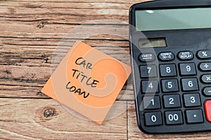 Concept of Car Title Loan write on sticky notes isolated on Wooden Table