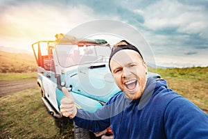 Concept car travel safari park tour in Africa summer. Happy man traveler make selfie photo on background of extreme ATV