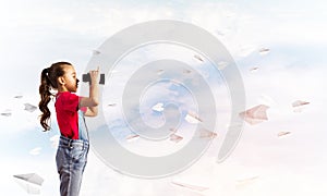 Concept of careless happy childhood with girl looking in binoculars