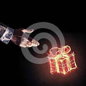 Concept of celebration with fire burning gift symbol and businessman palm