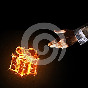 Concept of celebration with fire burning gift symbol and businessman palm