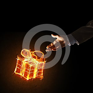 Concept of celebration with fire burning gift symbol and businessman palm