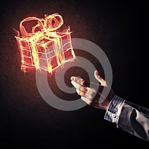 Concept of celebration with fire burning gift symbol and businessman palm