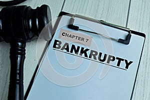 Concept of Chapter 7 - Bankrupty write on paperwork with gavel isolated on wooden background