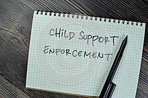 Concept of Child Support Enforcement write on a book isolated on Wooden Table