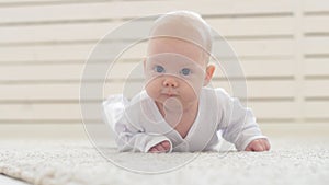 Concept of children and parenthood. Cute Happy Baby is Lying on Carpet