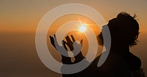 Concept Christian person worship or pray to God. Christian man silhouette with love, faith, devotion to God with sunrise sky