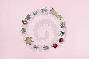 Concept of Christmas Wreath Consisting of Green Fir Branches Gingerbread Cookies and Red Christmas Balls Holiday Pink Background